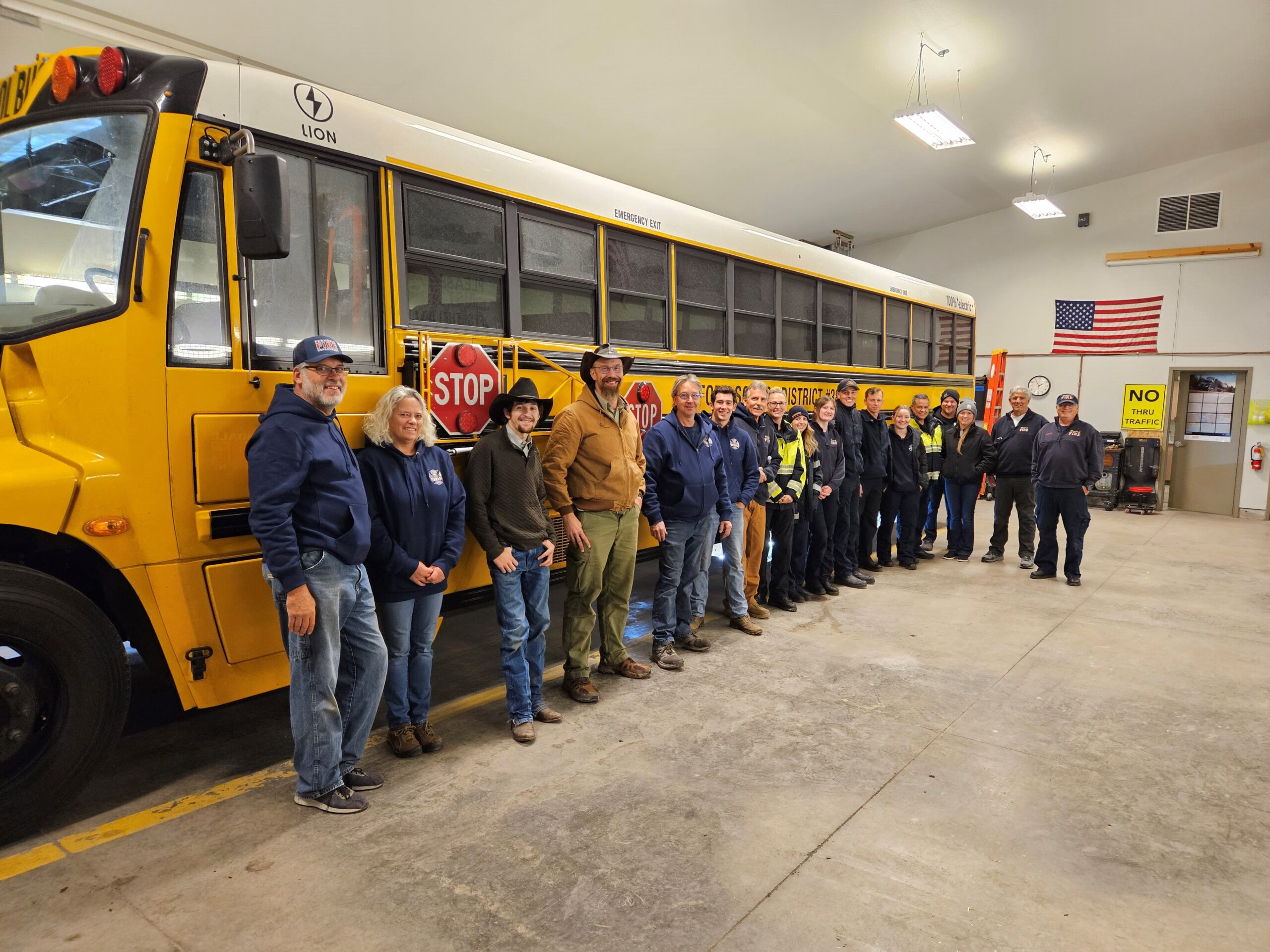 Members of Bigfork and Ferndale fire departments stand in front of Bigfork's electric school bus after completing a safety training on the bus.