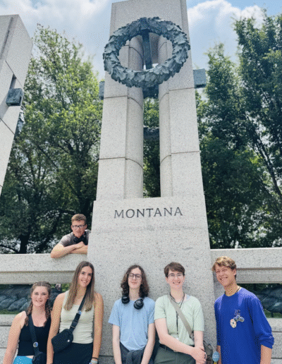Bigfork High School NHD students surround a granite pillar with the Montana inscription at the World War II memorial in Washington D.C.
